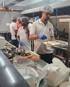Our kitchen team plating food with gloves